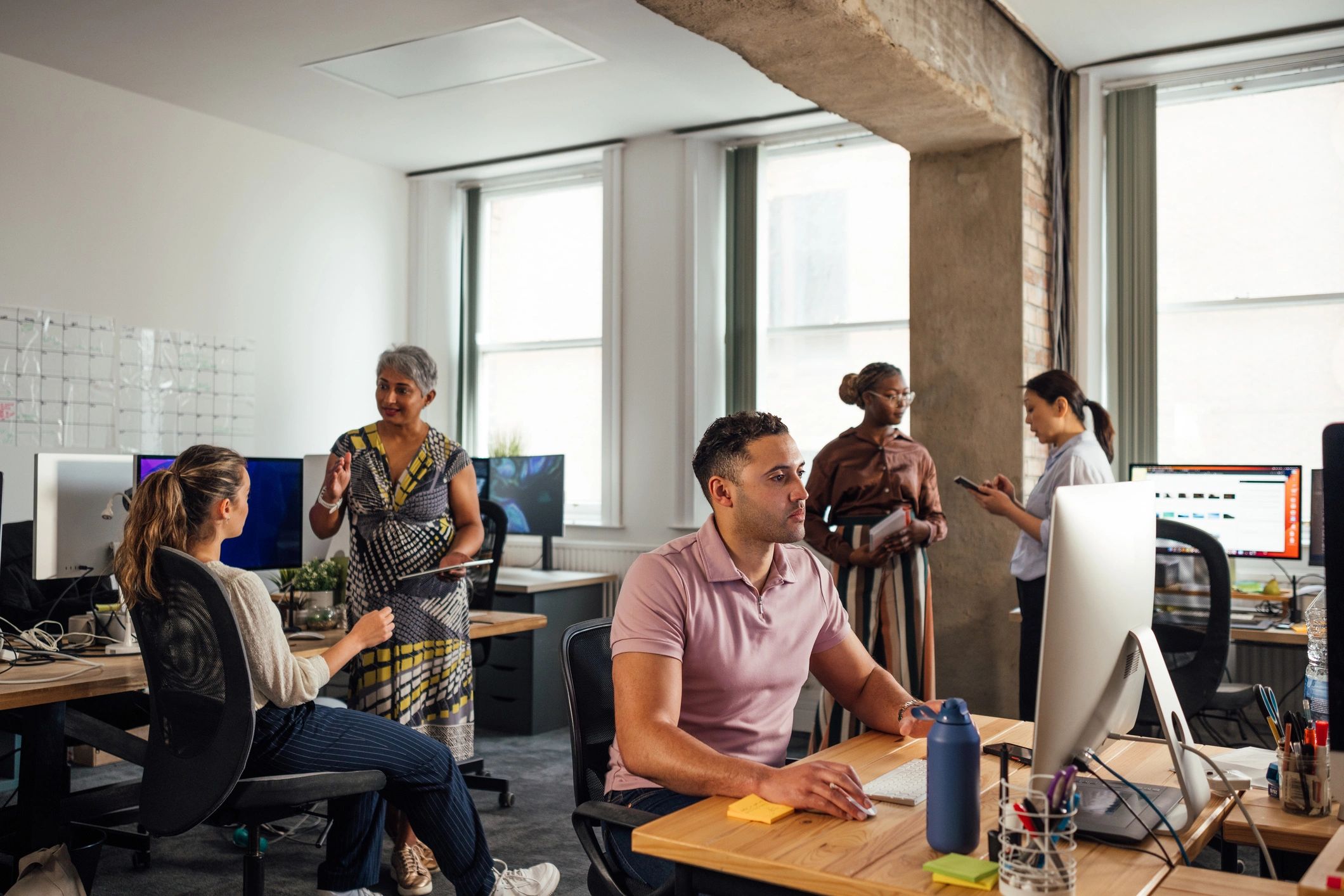 Office team working together at desks in a digital workspace