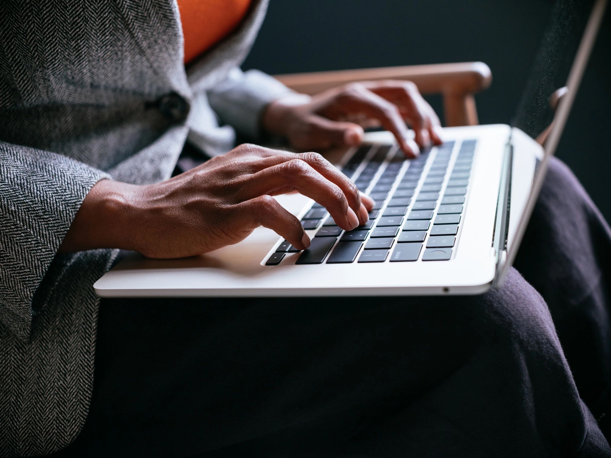 Focused Professional Typing on Laptop Keyboard Indoors